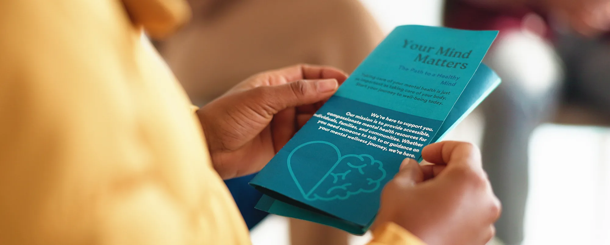 Hands, person and reading brochure in therapy for mental health info, treatment options or about us. Psychology, patient and leaflet in counseling for support resources, education or stigma reduction